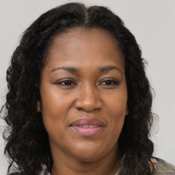 Joyful black adult female with long  brown hair and brown eyes