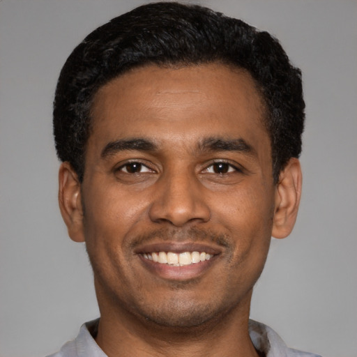 Joyful latino young-adult male with short  black hair and brown eyes