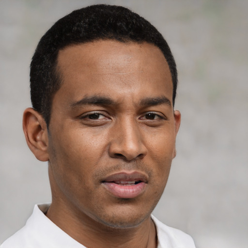 Joyful black young-adult male with short  brown hair and brown eyes