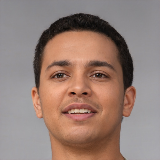 Joyful latino young-adult male with short  brown hair and brown eyes