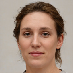 Joyful white young-adult female with medium  brown hair and grey eyes