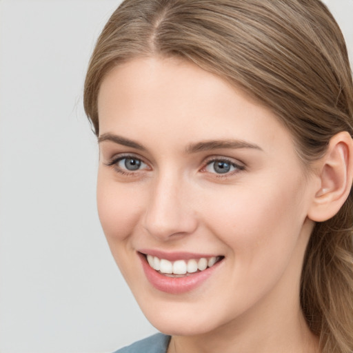 Joyful white young-adult female with long  brown hair and grey eyes