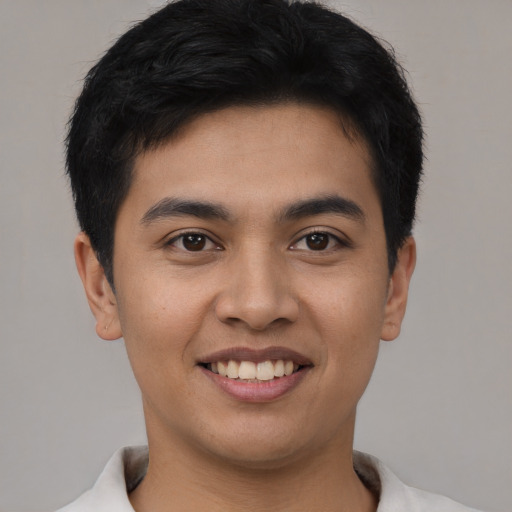 Joyful latino young-adult male with short  brown hair and brown eyes