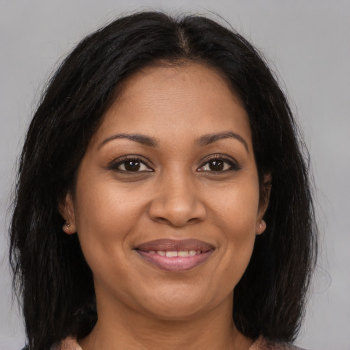 Joyful black adult female with medium  brown hair and brown eyes