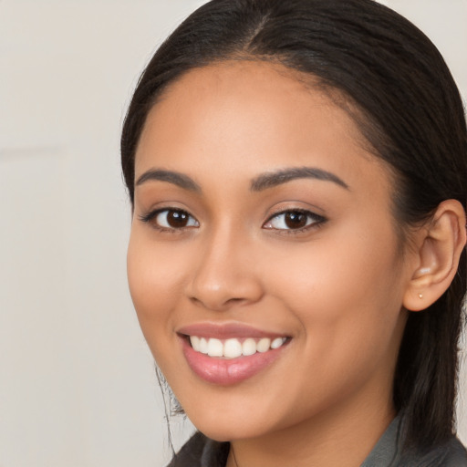 Joyful latino young-adult female with long  brown hair and brown eyes