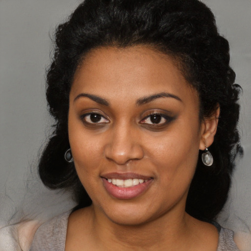 Joyful black young-adult female with long  black hair and brown eyes