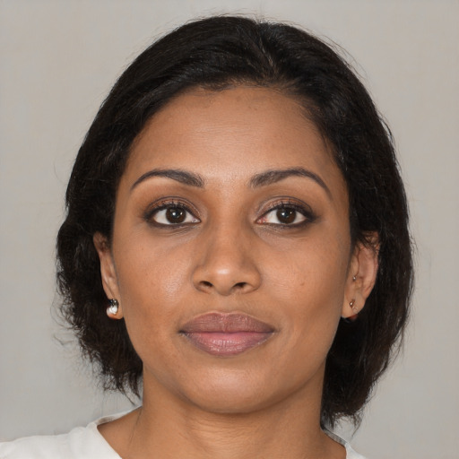 Joyful black young-adult female with medium  brown hair and brown eyes