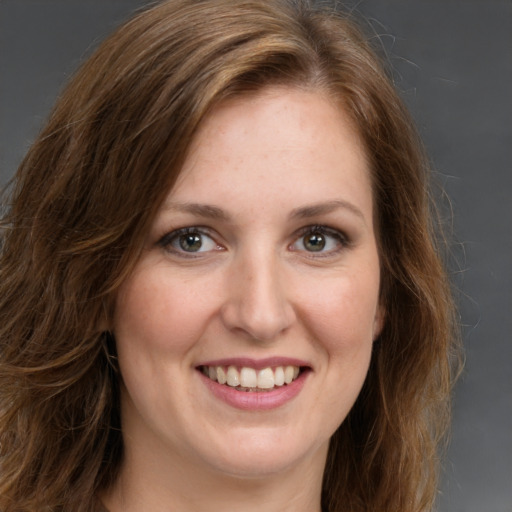 Joyful white young-adult female with long  brown hair and green eyes