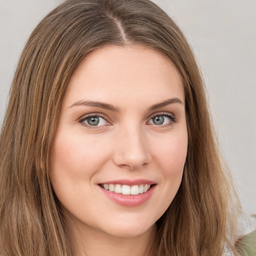 Joyful white young-adult female with long  brown hair and green eyes