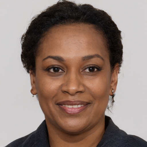 Joyful black adult female with short  brown hair and brown eyes