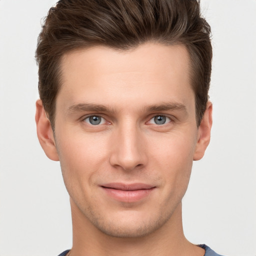 Joyful white young-adult male with short  brown hair and grey eyes