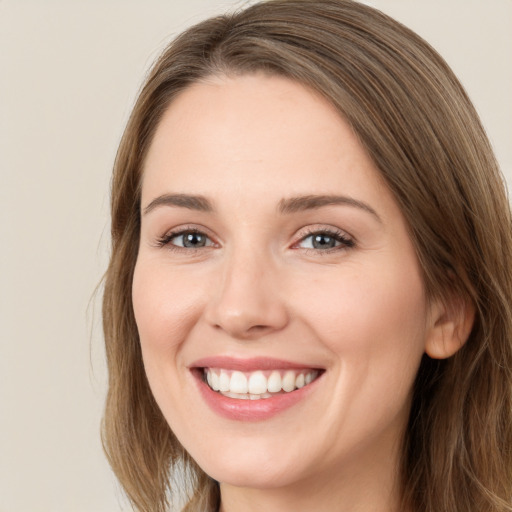 Joyful white young-adult female with long  brown hair and brown eyes