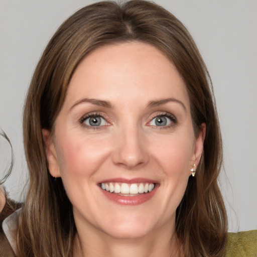 Joyful white young-adult female with medium  brown hair and grey eyes