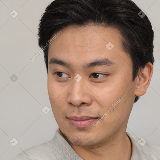 Joyful asian young-adult male with short  brown hair and brown eyes