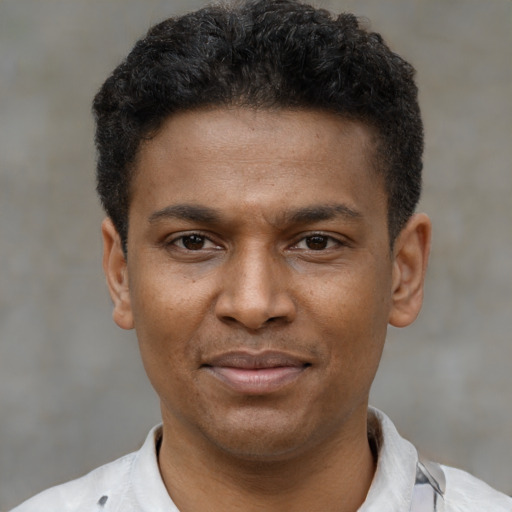 Joyful latino young-adult male with short  brown hair and brown eyes