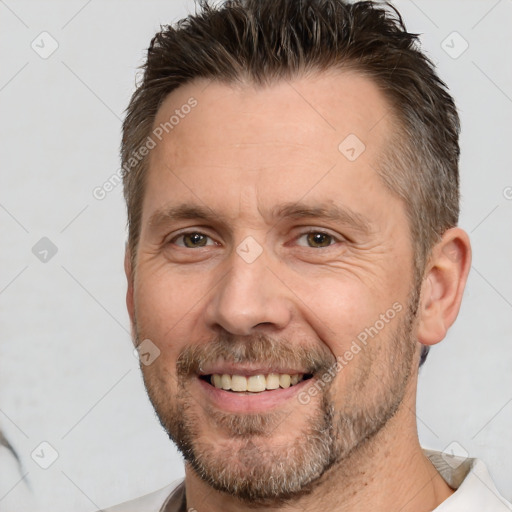 Joyful white adult male with short  brown hair and brown eyes