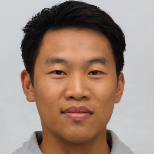 Joyful asian young-adult male with short  black hair and brown eyes