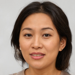 Joyful asian adult female with medium  brown hair and brown eyes