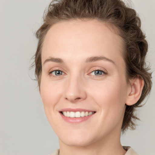 Joyful white young-adult female with medium  brown hair and green eyes