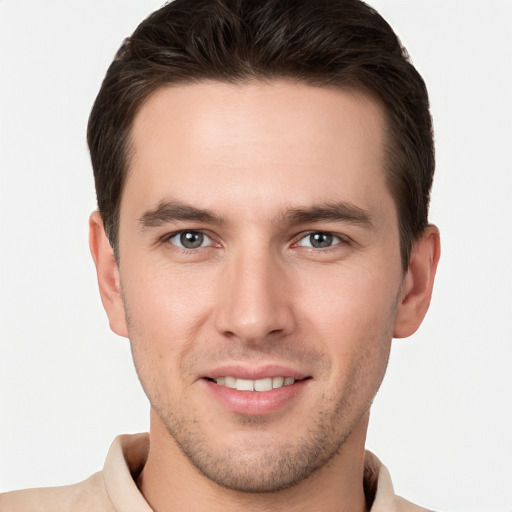 Joyful white young-adult male with short  brown hair and grey eyes