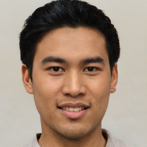 Joyful asian young-adult male with short  black hair and brown eyes