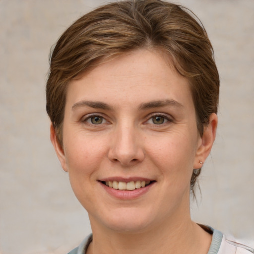 Joyful white young-adult female with short  brown hair and grey eyes