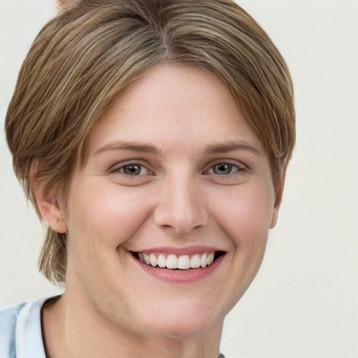 Joyful white young-adult female with short  brown hair and blue eyes