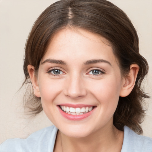 Joyful white young-adult female with medium  brown hair and blue eyes