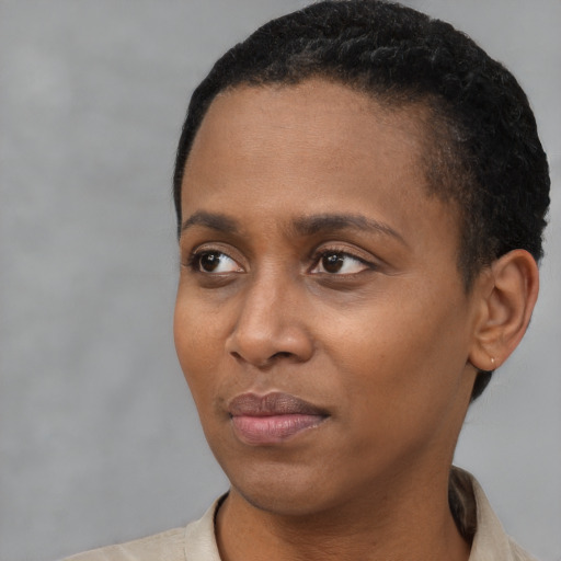 Joyful black young-adult female with short  black hair and brown eyes