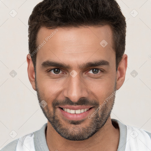 Joyful white young-adult male with short  brown hair and brown eyes