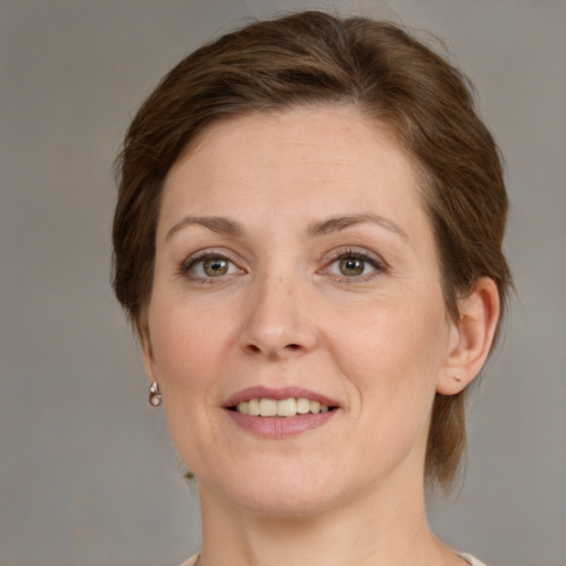 Joyful white adult female with medium  brown hair and green eyes