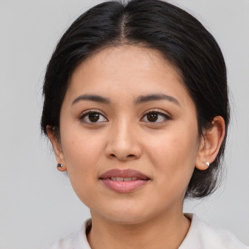 Joyful latino young-adult female with medium  brown hair and brown eyes