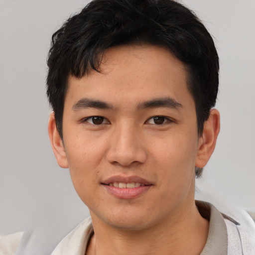 Joyful asian young-adult male with short  black hair and brown eyes