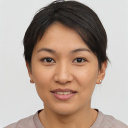 Joyful asian young-adult female with short  brown hair and brown eyes