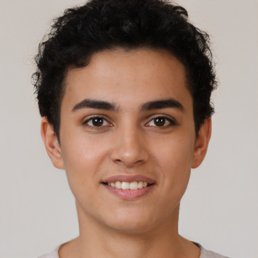 Joyful latino young-adult male with short  brown hair and brown eyes