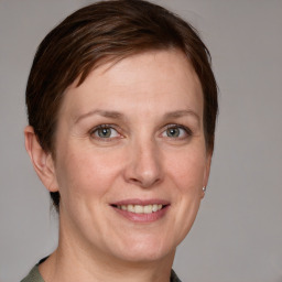 Joyful white adult female with medium  brown hair and grey eyes