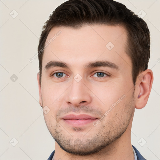 Joyful white young-adult male with short  brown hair and brown eyes