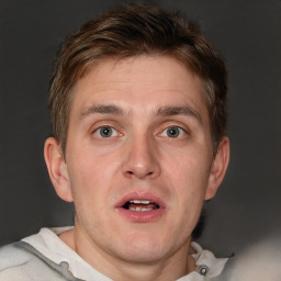 Joyful white adult male with short  brown hair and grey eyes