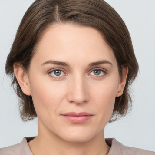 Joyful white young-adult female with medium  brown hair and grey eyes