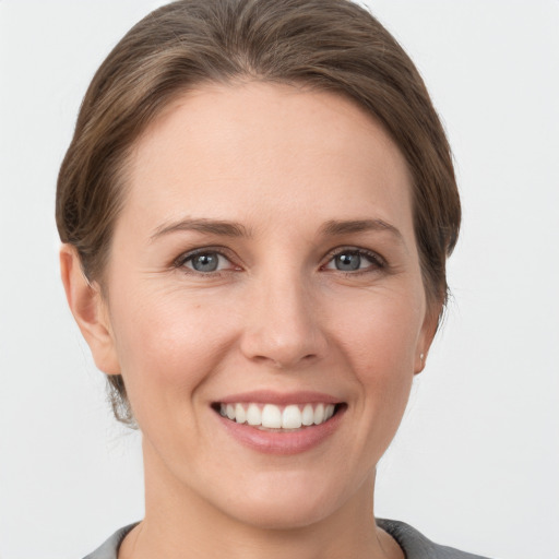 Joyful white young-adult female with short  brown hair and grey eyes