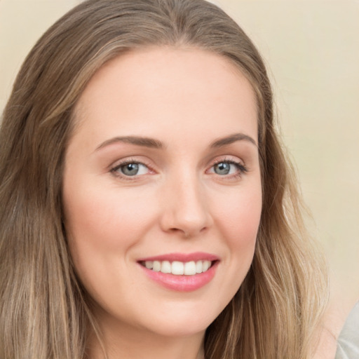 Joyful white young-adult female with long  brown hair and green eyes