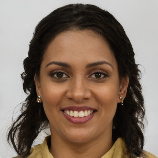 Joyful black young-adult female with long  brown hair and brown eyes
