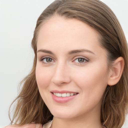 Joyful white young-adult female with long  brown hair and blue eyes