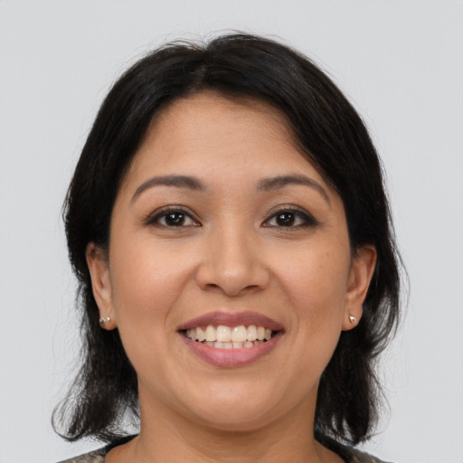 Joyful latino young-adult female with medium  brown hair and brown eyes