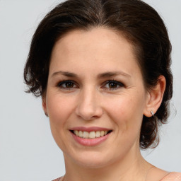 Joyful white young-adult female with medium  brown hair and green eyes