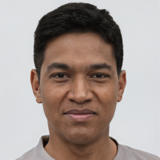 Joyful black young-adult male with short  black hair and brown eyes