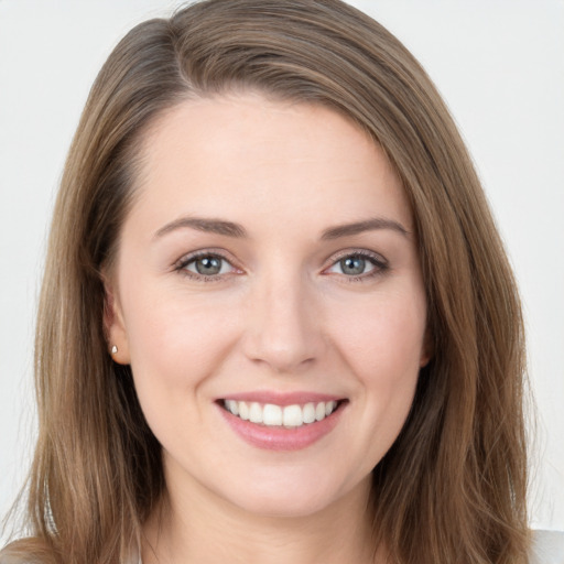 Joyful white young-adult female with long  brown hair and grey eyes