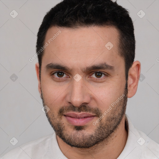 Joyful white young-adult male with short  black hair and brown eyes