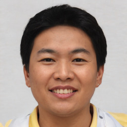 Joyful asian young-adult male with short  black hair and brown eyes