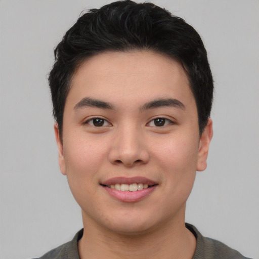 Joyful asian young-adult male with short  brown hair and brown eyes